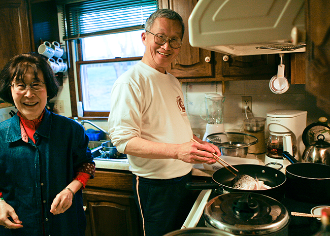 Dad cooking fish at home in Murrysville, with Mom next to him