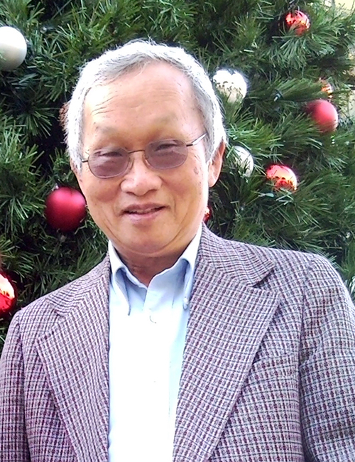 Dad standing in front of a Christmas tree, December 2010